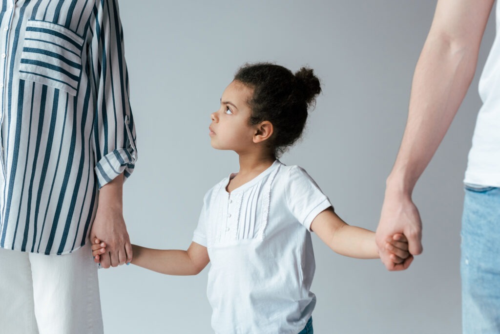 little girl holding parents hands