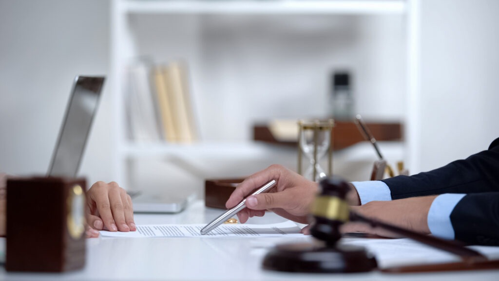 Attorney showing woman where to sign divorce document